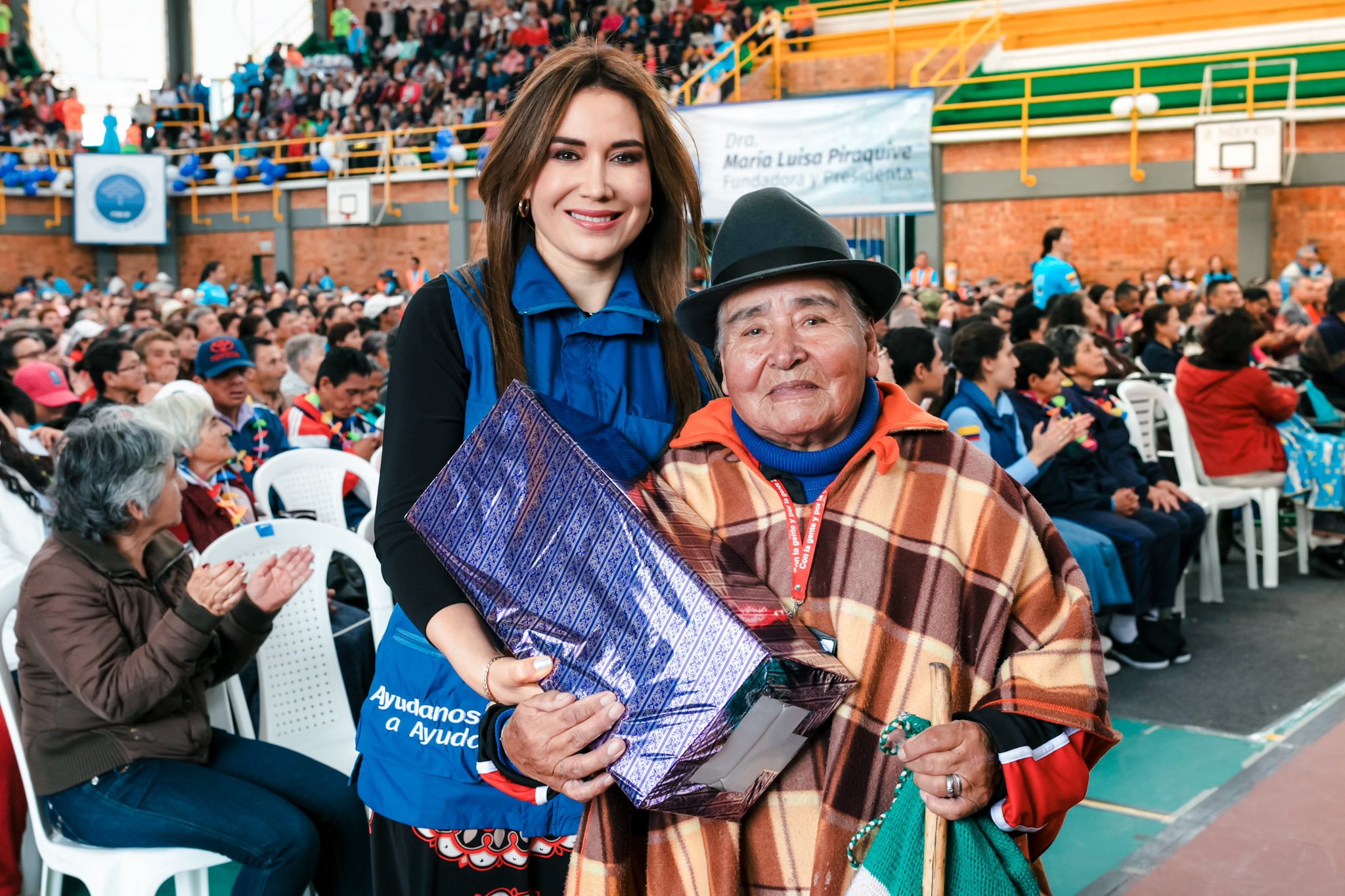 Dra. Ángela Oviedo entregando un obsequio a un beneficiario en un evento de la Fundación