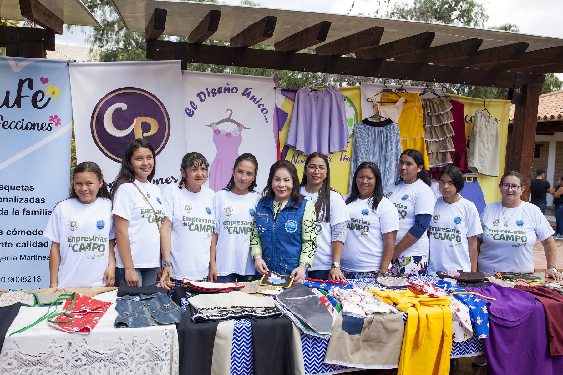 Familias emprendedoras junto a la Dra. María Luisa Piraquive en una feria de emprendimiento.