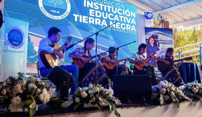 Estudiantes con traje típico santandereano interpretan tiples y bandolas junto a su profesor durante la ceremonia de inauguración.