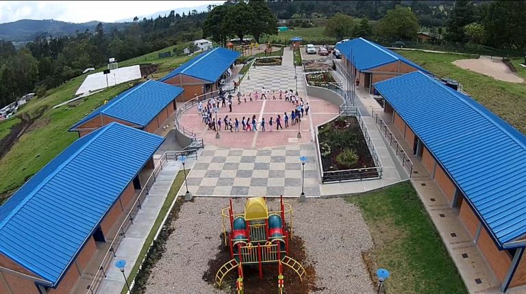 Vista aérea de la plazoleta central con los estudiantes formando un círculo tomados de la mano durante una actividad.