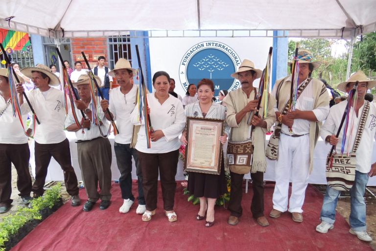 Las autoridades del cabildo indígena Tama Páez, con sus bastones de mando y ruanas tejidas, entregan a la Dra. María Luisa de Moreno un homenaje enmarcado.