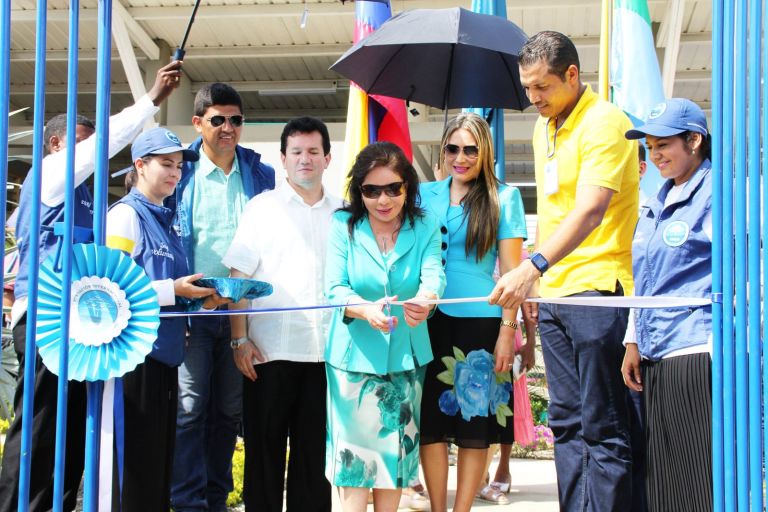 La Dra. María Luisa de Moreno corta la cinta en la puerta de la nueva escuela, acompañada por autoridades locales y voluntarios de la Fundación.