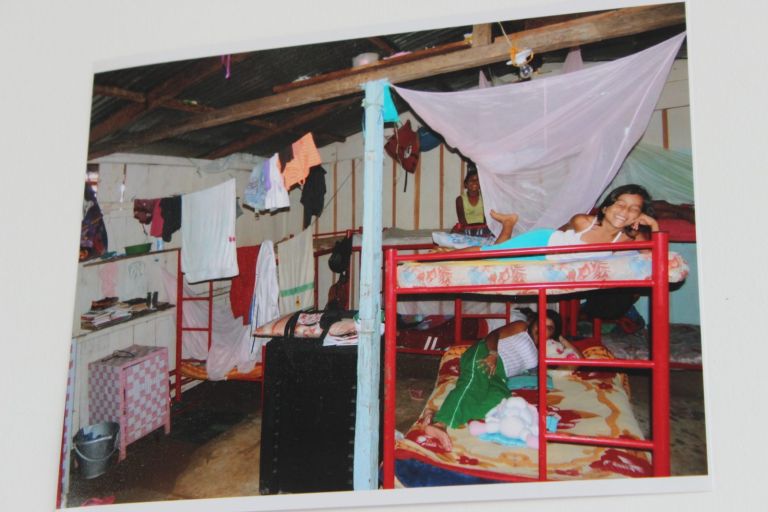 El dormitorio del antiguo albergue: camarotes rojos con toldillos, ropa colgada de cuerdas y paredes de tablas, donde dormían los niños para protegerse de la violencia.