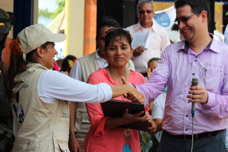Una representante de la Fundación estrecha la mano de un representante de la Gobernación del Caquetá durante la ceremonia.