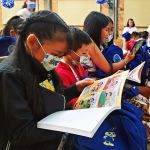 Los niños beneficiados observan sus cuadernos