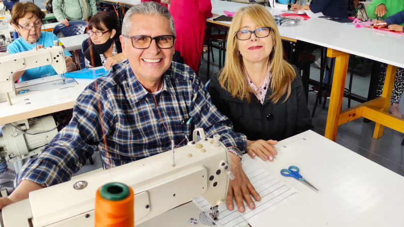 Hombres y mujeres se capacitan en el manejo de máquinas de coser
