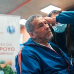 Un hombre recibiendo un chequeo en sus oídos por una profesional, durante una Jornada de Salud.