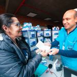 Un hombre voluntario de la Fundación entregando suministros a una mujer en un evento comunitario.