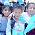 Las tres niñas están abrazadas muy felices de recibir su cono sorpresa de regalo