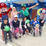 Cuatro niños están posando con las pelotas de regalo que les dio la Fundación, algunos de ellos tiene discapacidad motora y cognitiva.