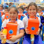 Dos niñas muy felices muestran con alegría sus cajitas de regalo y sus refrescos para ver la película del Tele Cine.