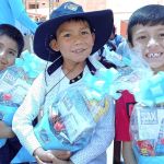 Tres niños mostrando su regalo, felices por los conos sorpresas que recibieron