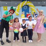 Tres niñas de 6 años muestran felices las pelotas de regalo y posan junto a Luigi y la princesa Peach, personajes de Mario Bros