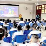 El grupo total de niños están muy atentos a la película, aprendiendo sobre las emociones.