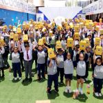 Todos los niños levantando su cajita sorpresa que contiene regalos, palomitas de maíz y bebidas