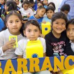 Cuatro niñas felices sonríen en el marco decorado mostrando su regalo