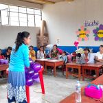 Voluntaria enseñando el taller de globos al grupo de mujeres