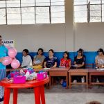 Voluntaria enseña al grupo de mujeres el taller de globos