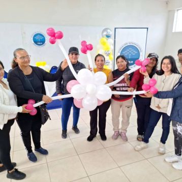 Mujeres comparten el trabajo de globos realizado en clase.