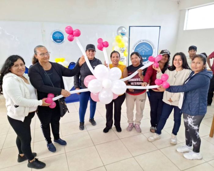Mujeres comparten el trabajo de globos realizado en clase.