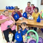 Los beneficiados con sus familias, muestran los regalos que reciben de la Fundación.