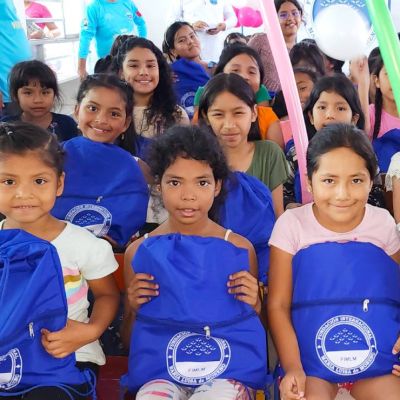 El grupo de niñas felices reciben su kit escolar