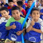 Tres niños felices con sus kits escolares