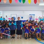 Todo los niños sentados miran a la cámara con sus regalos