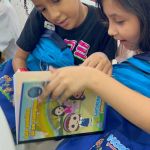 Niñas beneficiarias de jornada revisan con alegría sus kits escolares