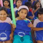 Tres niñas con mucha alegría muestran sus regalos de kits escolares