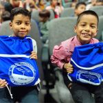 Niños sonriendo en señal de agradecimiento con la FIMLM por la entrega de kits escolares