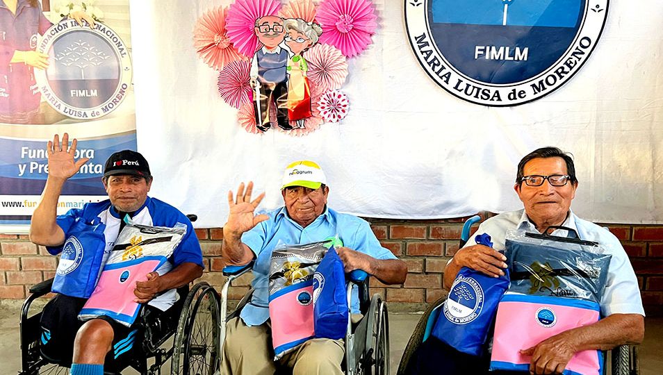 Tres adultos mayores en silla de ruedas exhiben su regalo