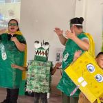 Eco-héroes interactúan alegremente con dos beneficiarios disfrazados de personajes animados hecho de materiales reciclados