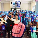 Los beneficiarios exhiben los regalos al lado de los artistas de la marinera