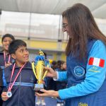 La directora de la Fundación en Perú entrega el trofeo a niño