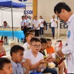 Voluntario con sonrisa amable hace entrega de un delicioso refrigerio