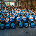 Multitud de niños y niñas con sus nuevos uniformes y kits escolares
