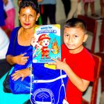 El niño muestra el regalo al lado de su madre