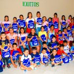Todos los niños al frente del escenario, muestran su regalo