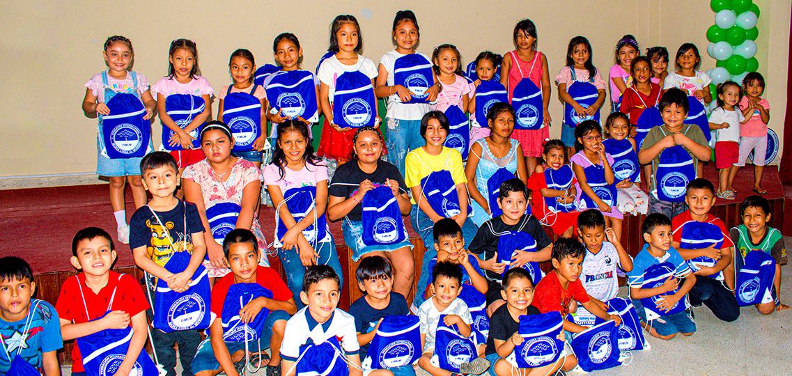 Todos los niños al frente del escenario, muestran su regalo