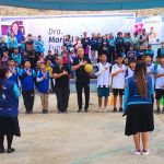Los niños, los voluntarios y los asistentes dan inicio al torneo de fútbol.
