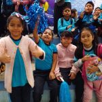 Las niñas felices animan y alientan a su equipo con porras y alegría.