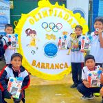 Niños sonrientes posan con las medallas, el trofeo y los regalos