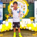 Niño con la medalla, trofeo y regalo