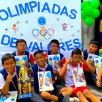 Niños muestran las medallas, el trofeo y los regalos