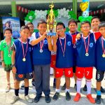Niños muestran las medallas y el trofeo