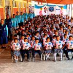 Los niños beneficiados muestran sus regalos y sonríen. Junto a ellos están los voluntarios.