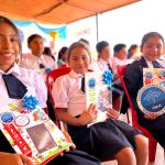 Cuatro niñas sonríen mostrando sus regalos