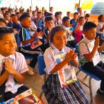 Niños aplaudiendo y sonriendo en medio del taller de valores