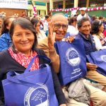 Tres adultos mayores felices con sus regalos sonríen